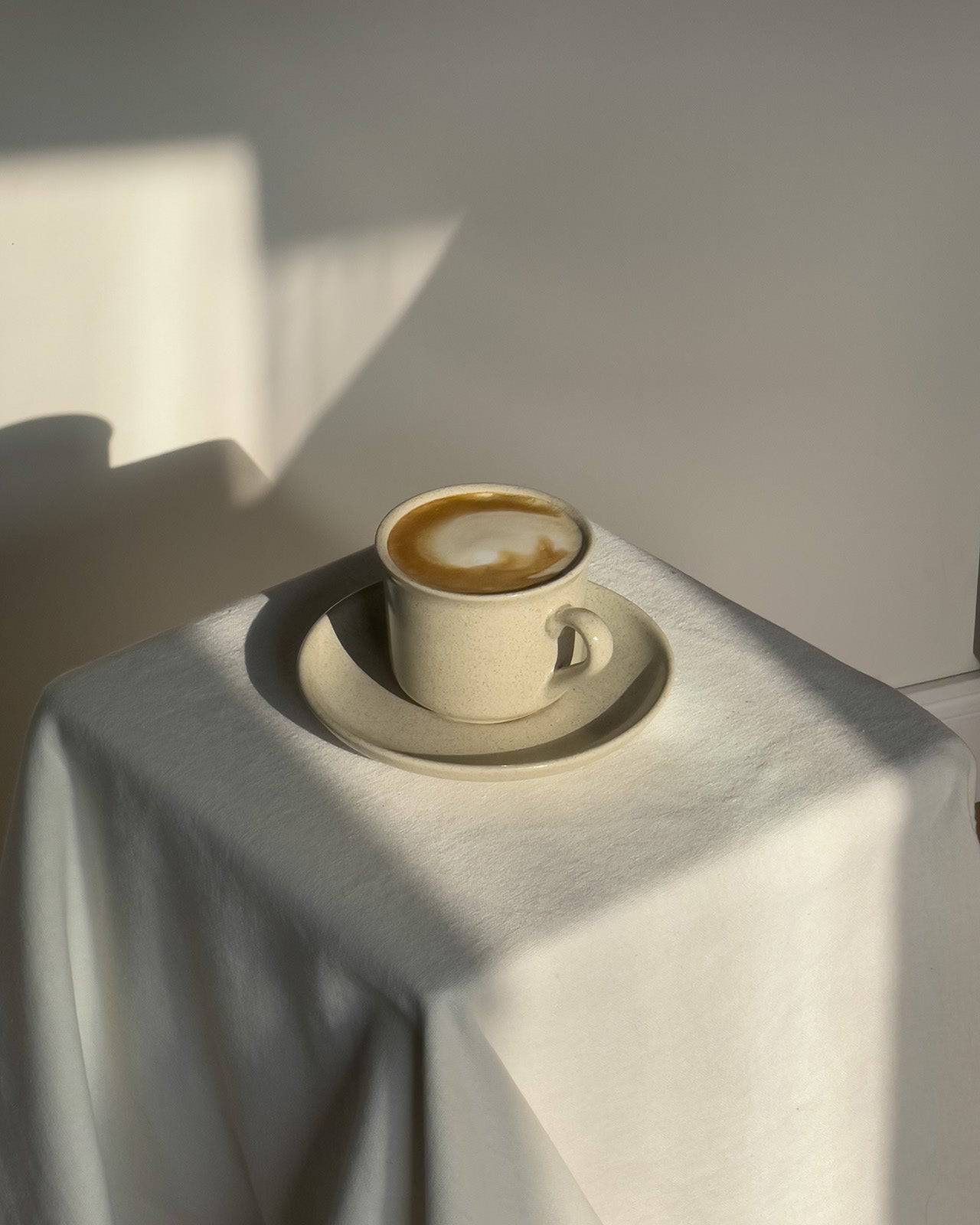 Keramiktasse aus der Viana-Kollekion auf Sockel mit Kaffee.