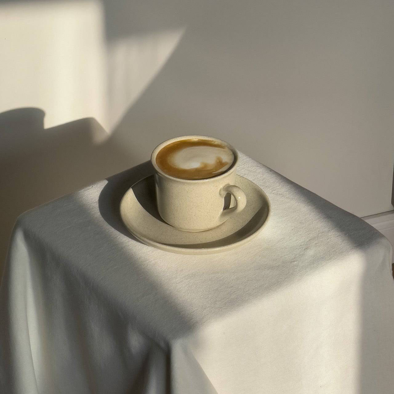 Keramiktasse aus der Viana-Kollekion auf Sockel mit Kaffee.