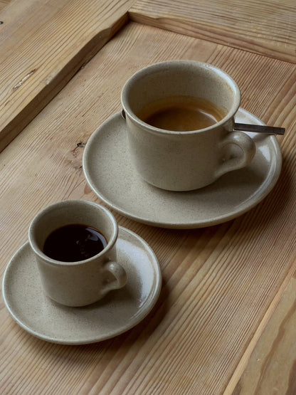 Keramiktassen mit Kaffee gefüllt auf Holztisch