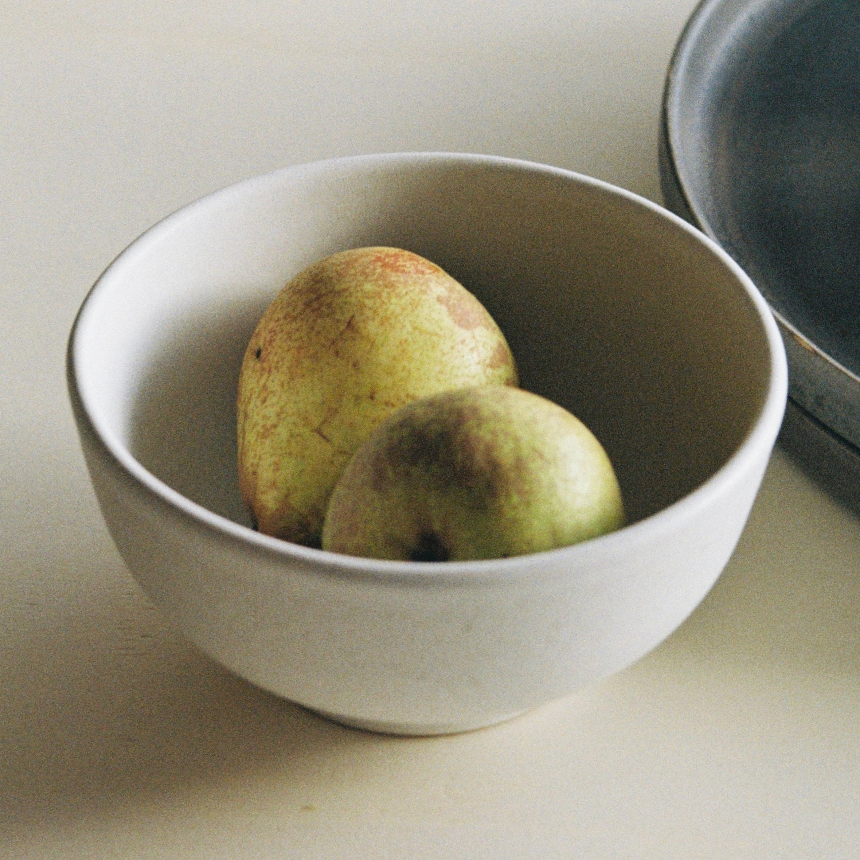Analogaufnahem von iner Steingut Schüssel weiß mit zwei Birnen