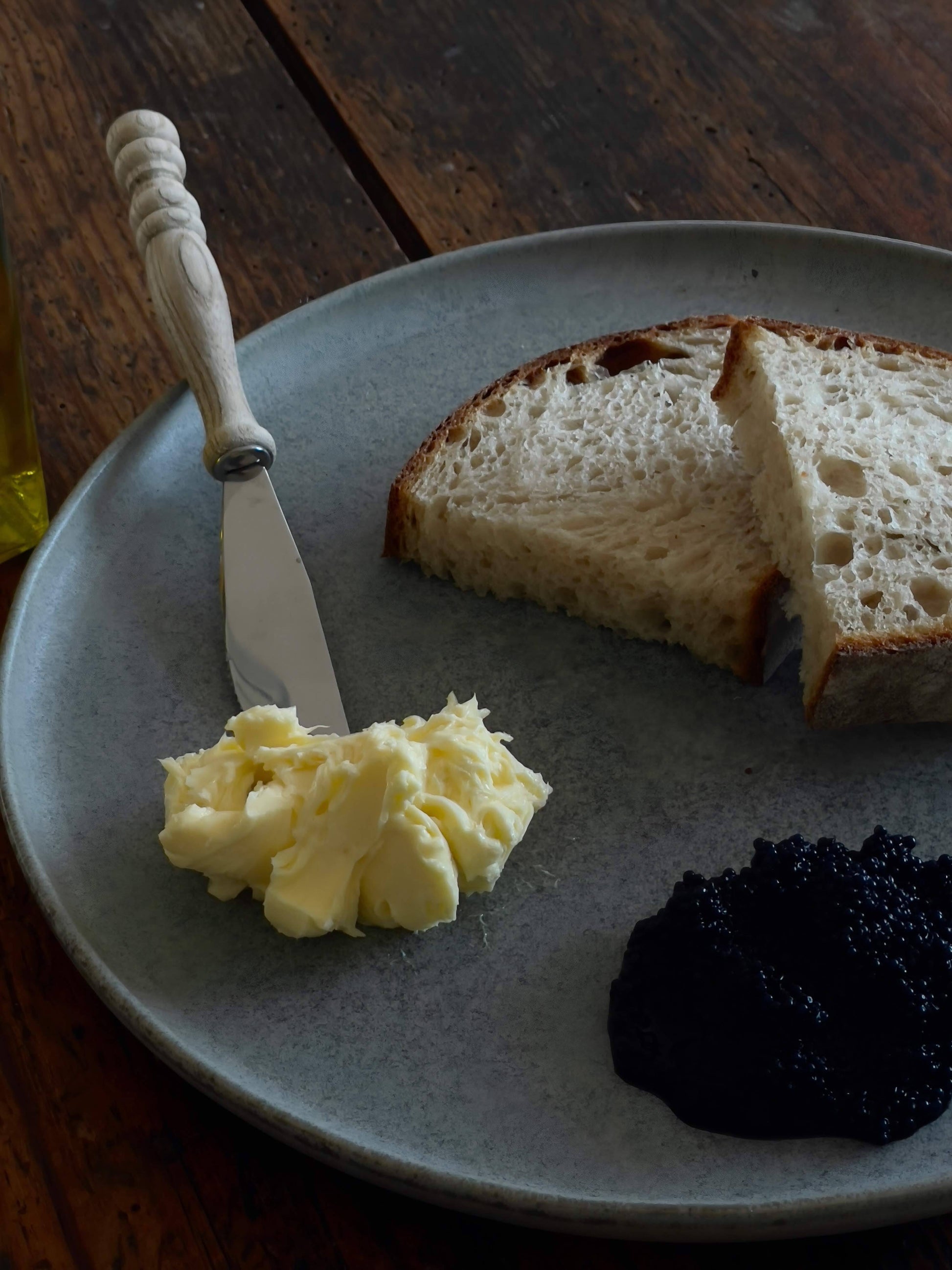 Mood Image großer Keramikteller Azul blau mit Brot und Butter, liegend auf Holztisch