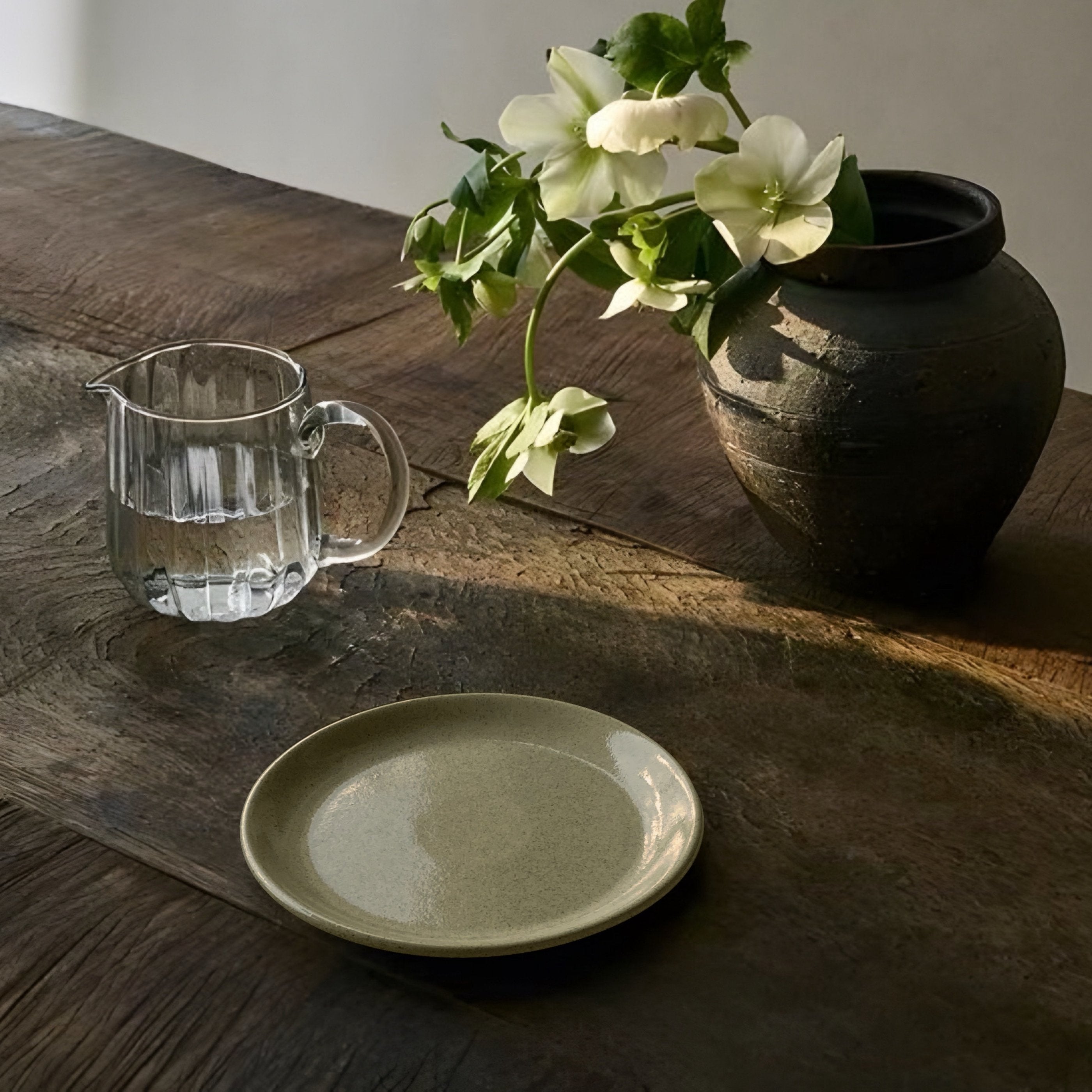 Kleiner Teller Viana aus Steinzeug auf Holztisch mit Blumenvase und Glaskaraffe
